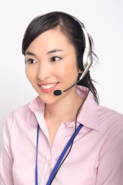 Kulaklıklı, gülümseyen genç bir kadının portresi.