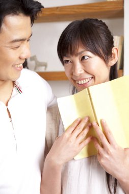 Mutlu genç çift oturma odasında kitap okuyor..