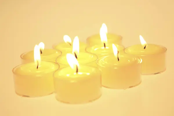 Veel Brandende Kaarsen Gele Achtergrond — Stockfoto