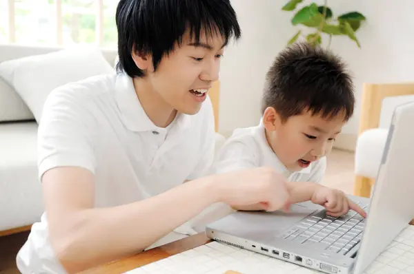 Ung Far Och Hans Son Använder Dator Tillsammans Hemma — Stockfoto