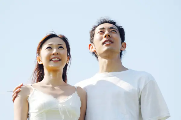 young asian couple looking at something outdoors
