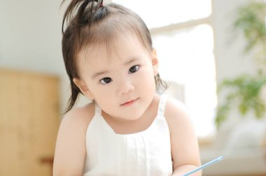 Küçük Asyalı kız evde oynuyor.