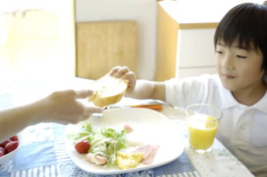 Genç anne ve oğlu öğle yemeği yiyorlar.