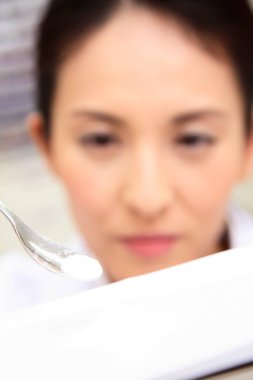 Laboratuvar önlüklü kadın Japon eczacı eczanede ilaç karıştırıyor.