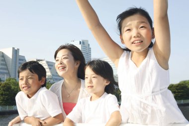 Dört kişilik aile köprünün üzerinde nehrin keyfini çıkarıyor. 