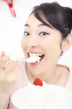 Pastalı Asyalı kadın, yiyor.