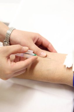 Doktor hastadan kan örneği alıyor.