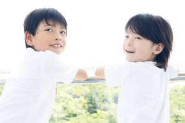 Şehirde gülümseyen iki Asyalı çocuk. mutluluk ve sağlıklı yaşam tarzı kavramı.