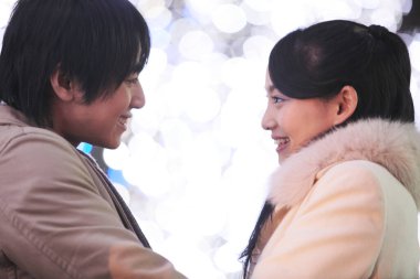 Genç Asyalı bir çiftin Noel panayırında birbirine aşık portresi. 