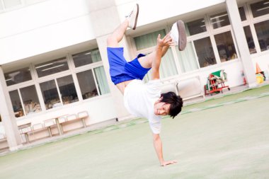 Genç adam spor salonunda esneme hareketleri yapıyor. 