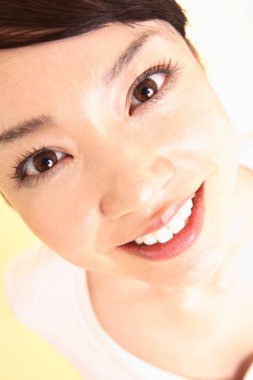 Stüdyoda gülümseyen genç Asyalı kadın. 