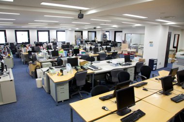 Bir sürü masası olan geniş açık bir ofis. 