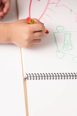 çocuk bir kurşun kalemle resim çizer.