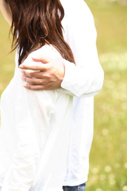 Erkek, bir kadını nazikçe omuzlarından tutar.