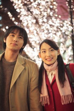 Genç Asyalı çift dışarıda poz veriyor.