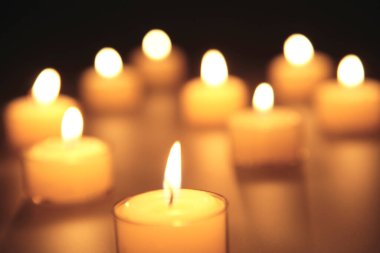 Siyah arka plan üzerine birçok yanan mumlar