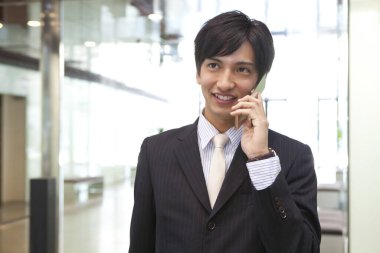 Takım elbiseli bir adam cep telefonuyla konuşuyor.