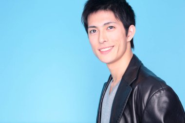 Mavi arka planda deri ceketli gülümseyen adam portresi 