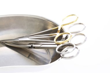 Surgical scissors placed inside stainless steel tray