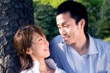 Parkta gülümseyen mutlu Asyalı erkek ve kadın