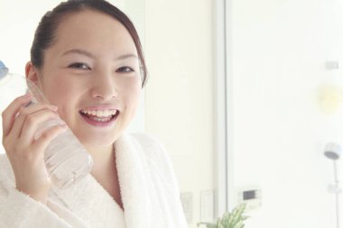 Sabah elinde su şişesi olan Asyalı kadın.