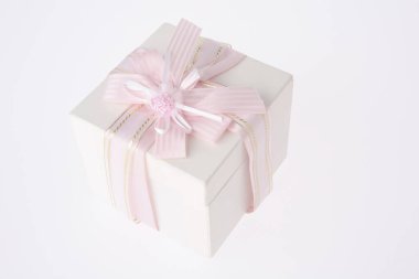 Beyaz arka planda pembe kurdeleli beyaz hediye kutusu