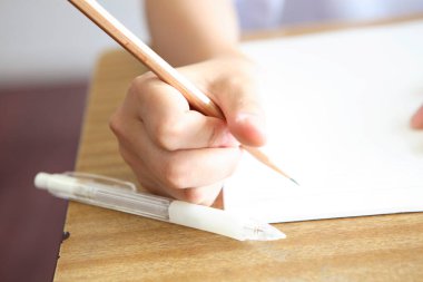 Kalemle beyaz kağıda resim çizen kadın