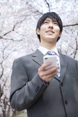 Parkta cep telefonu olan bir işadamı 