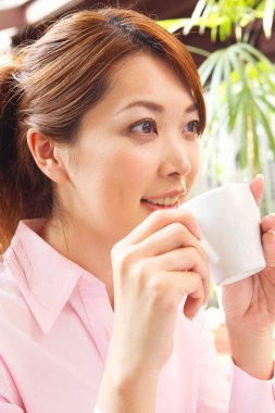 Elinde kahve tutan bir kadın.