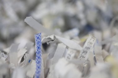 Parçalanmış kağıt parçaları bulanık arkaplana saçılmış.