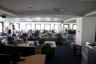 Bir sürü masası olan geniş açık bir ofis. 
