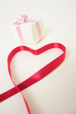 Kalp şeklinde kırmızı kurdeleli hediye kutusu. 