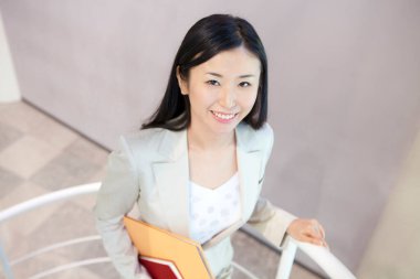 Ofisteki merdivenlerde kitabı olan kadın. 