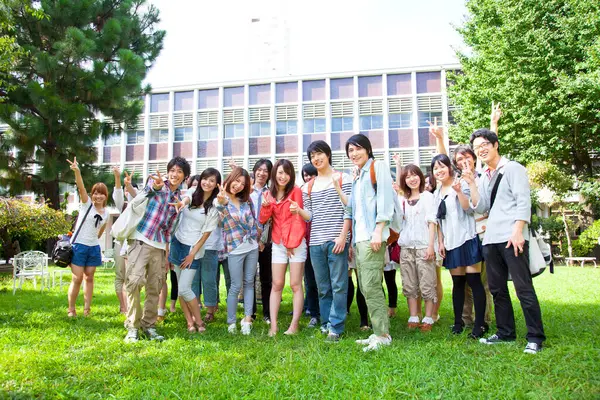 Ασιάτες Ευτυχισμένοι Φοιτητές Που Ποζάρουν Κοντά Στο Πανεπιστήμιο — Φωτογραφία Αρχείου