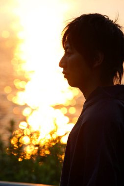 Suda gün batımında insan silueti