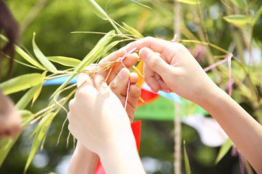 Kadın ve erkek dilek tutup ağaç dalına kurdele takıyor. 