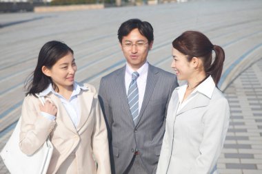 Yakışıklı Japon işadamının portresi. Sokakta poz veren iki iş kadını.