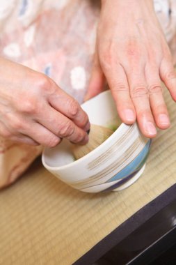 Kapalı kadın geleneksel Japon çayı hazırlıyor. 