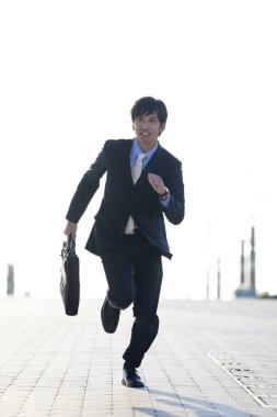 Sokakta koşan genç Asyalı adam. 