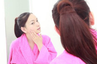 Banyoda aynası olan genç Asyalı kadın.