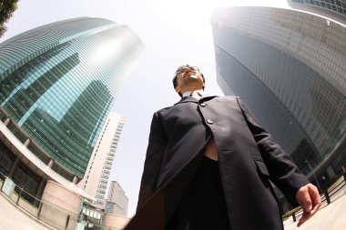 Gökdelenlerin önünde duran iş adamı