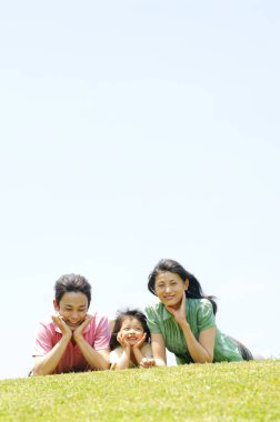 Aile yazın çimlerin üzerinde yatıyor. 