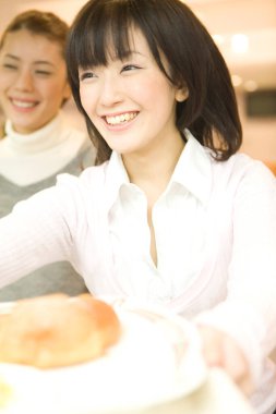 Mutfakta yemek servisi yapan gülümseyen kadınlar.