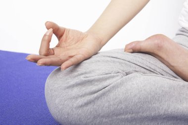 Yoga pozisyonundaki bir kadının kesilmiş fotoğrafı.