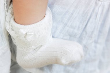 Battaniyeye beyaz dantel çorap giyen bebek