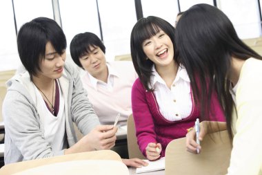 Bir grup Japon öğrenci konferans odasında oturuyor.