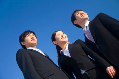 Mavi gökyüzü geçmişinde üç genç iş adamı