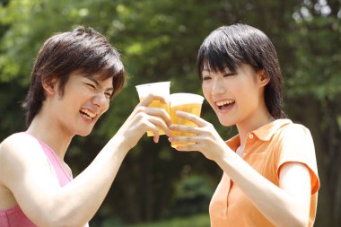 Parkta içki içen iki Asyalı arkadaş. 