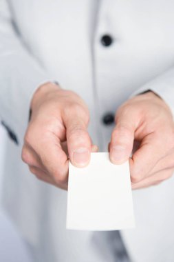 İş adamı elinde boş kartvizit tutuyor, beyaz arkaplanda izole edilmiş, kopyalama alanı
