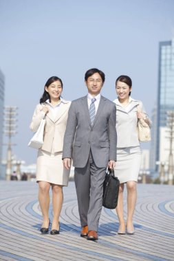 Yakışıklı Japon işadamının portresi. Sokakta poz veren iki iş kadını.